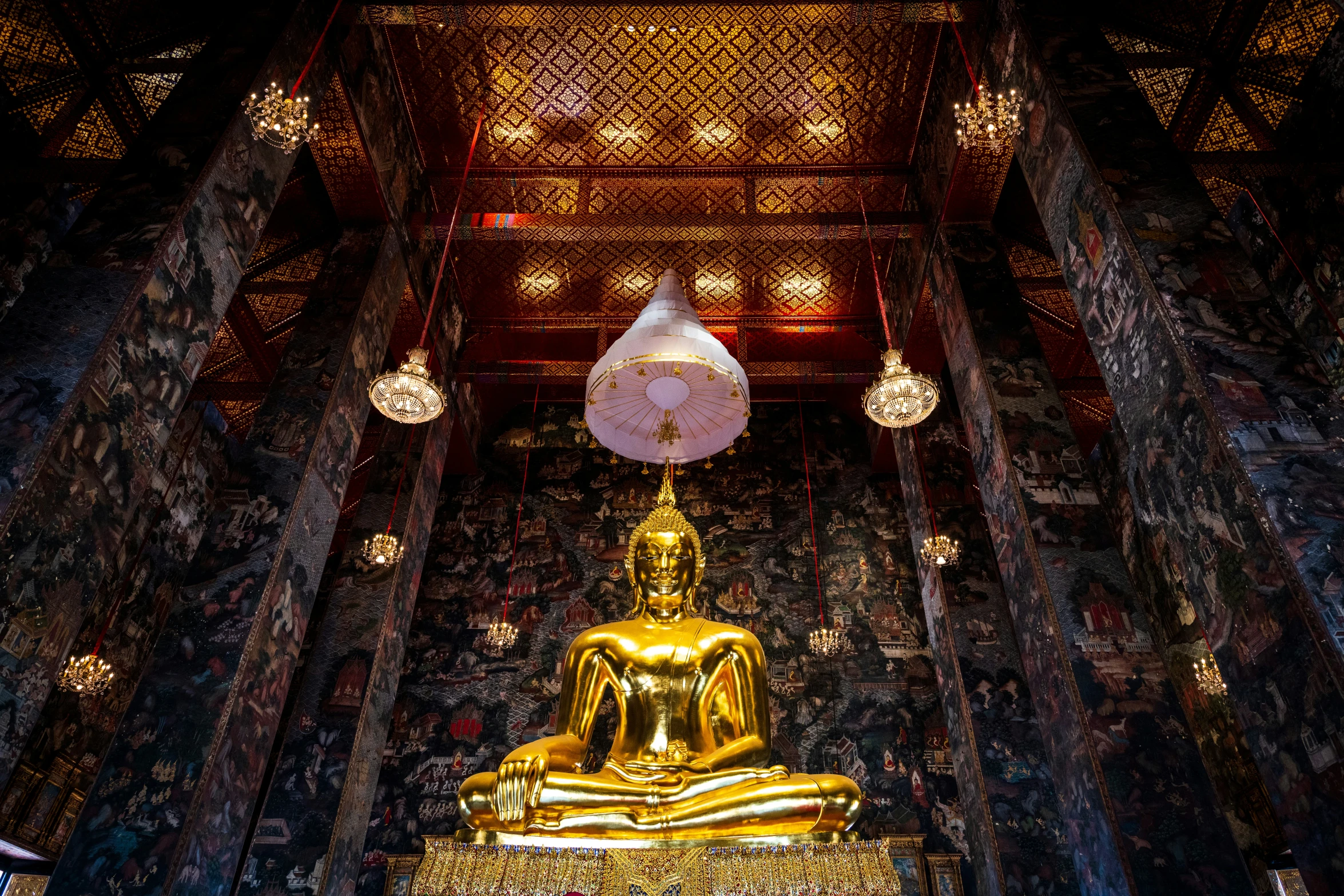a big buddha statue sitting on the side of a hallway
