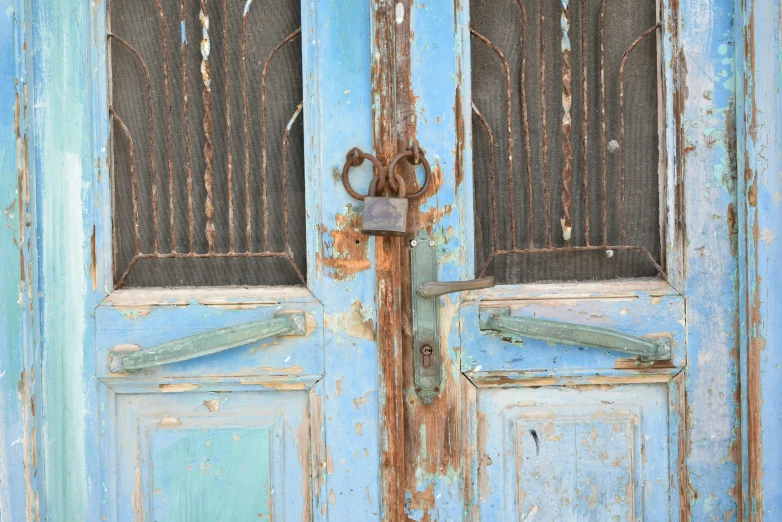 an old door with a rusty handle and grids