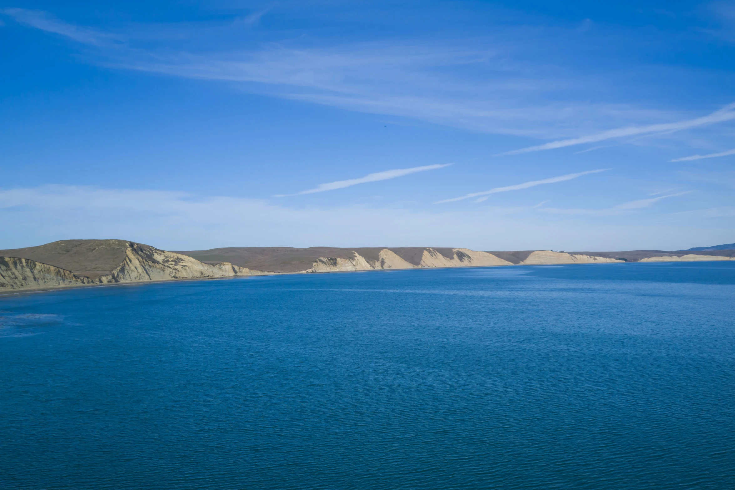 view of the cliffs of a large blue body of water