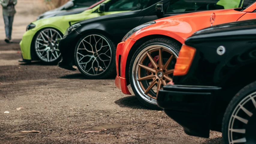 a row of different colored cars parked in a lot