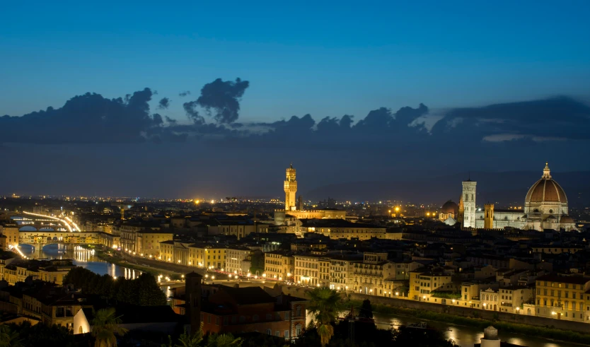 cityscape with lights on at dusk, overlooking water