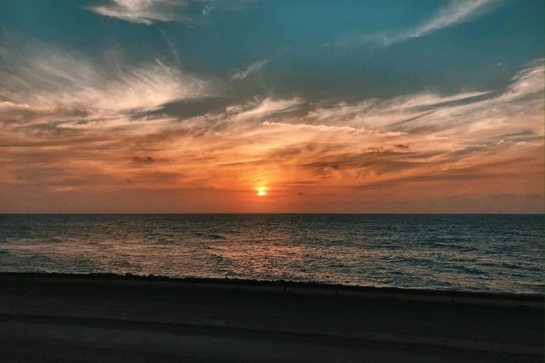 a large body of water with clouds in the sky