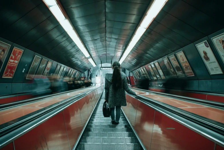 people are walking through a tunnel on a train platform