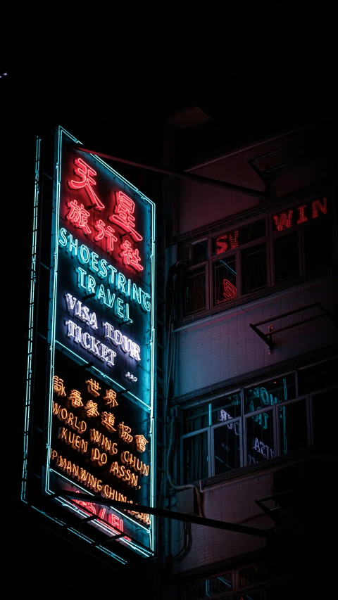 a neon sign advertising business in front of an apartment building