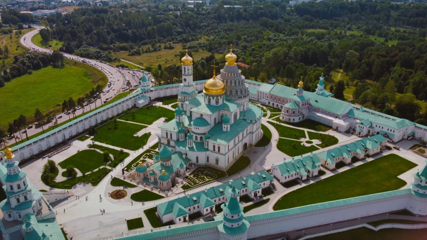 the large building with two domes is surrounded by lush green fields