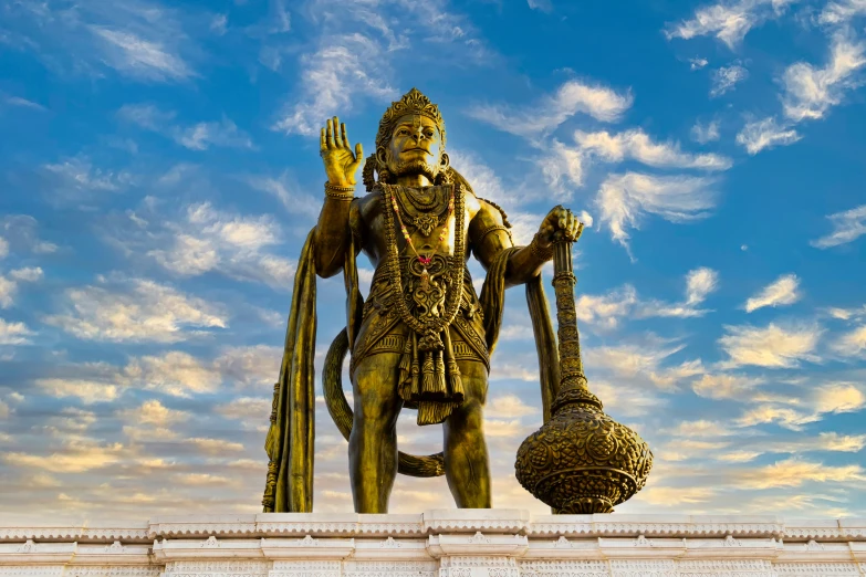 an artistic statue stands in front of the blue sky