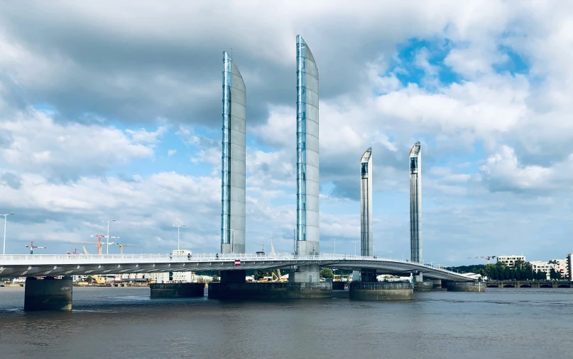 the bridge has a very tall tower near the river