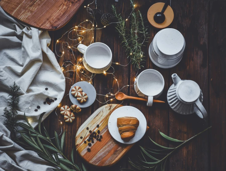 a table with tea and snacks is set with holiday lights