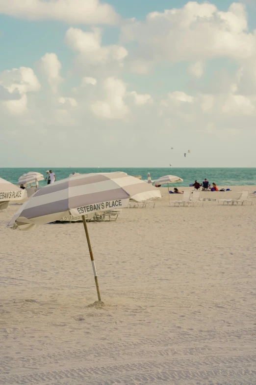 a white and gray umbrella on the sand