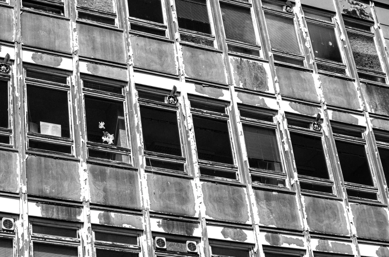 some broken windows in a tall building with lots of windows