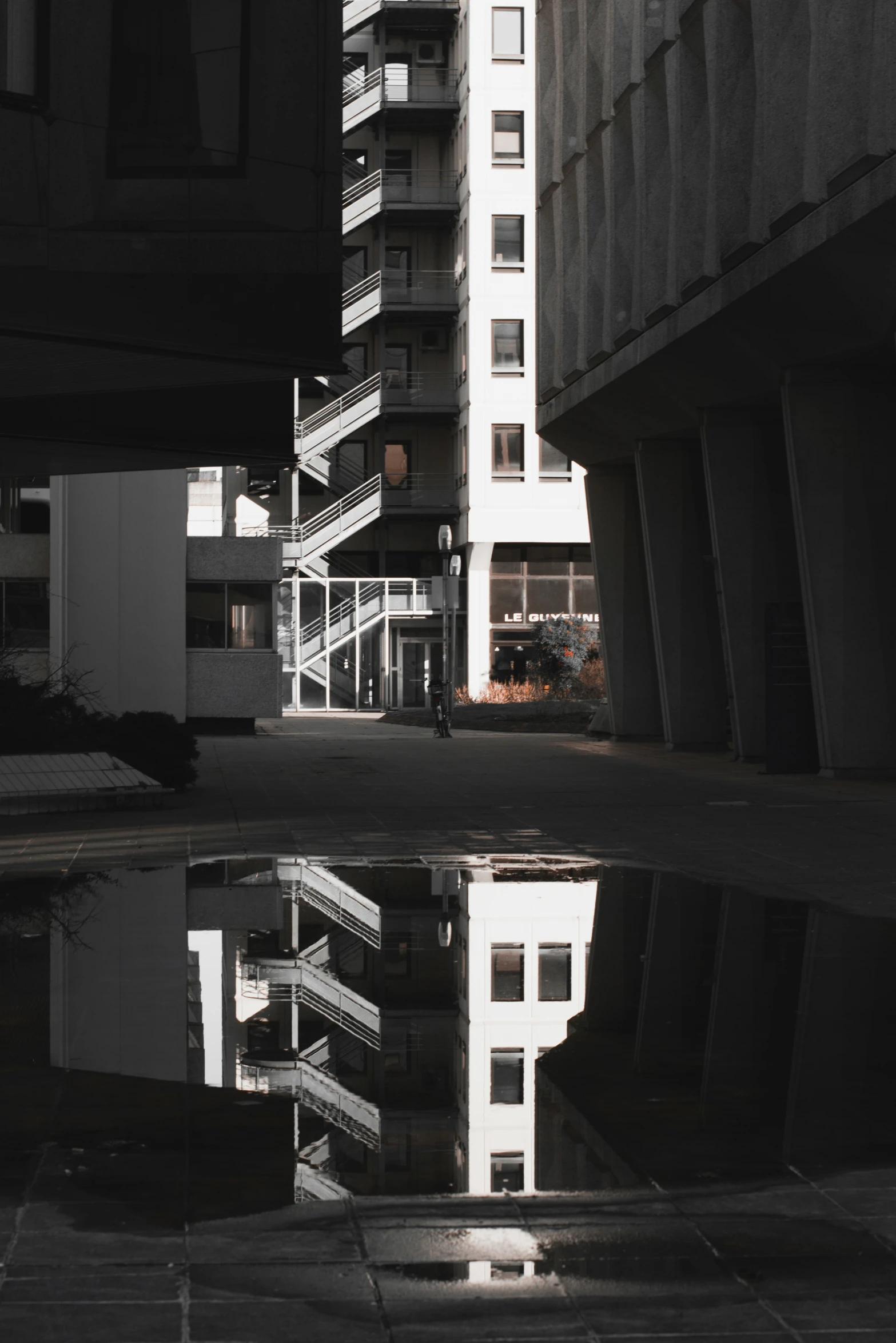 a tall building reflecting off of some water