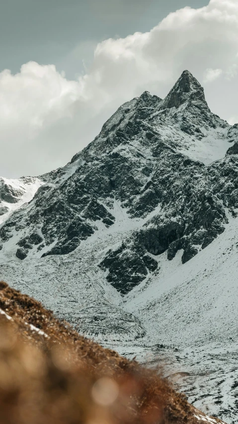 a snowy mountain covered in snow and low clouds