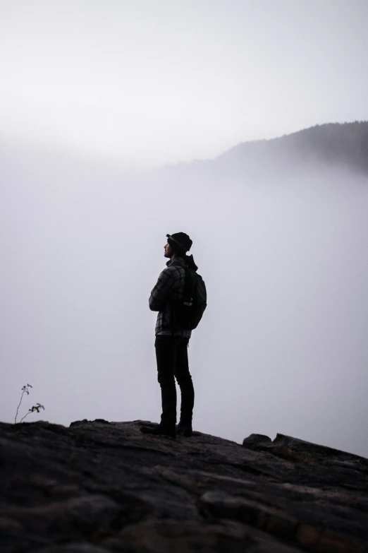 a person stands on the side of a rocky cliff