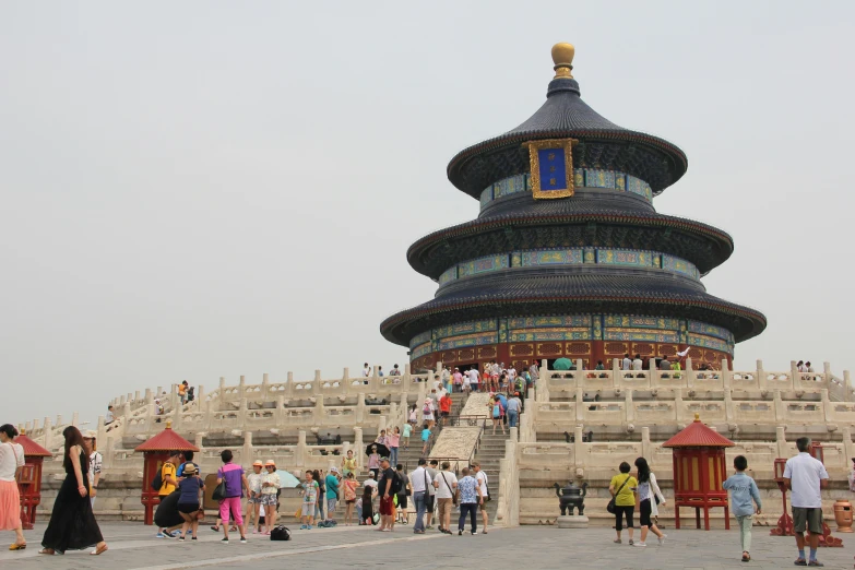 many people are standing around a large tower