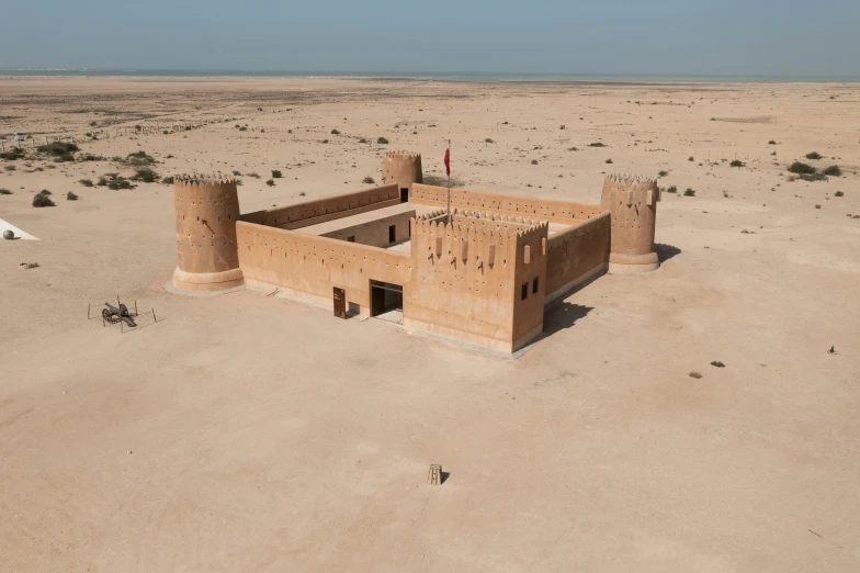 a large building in the middle of an open desert plain