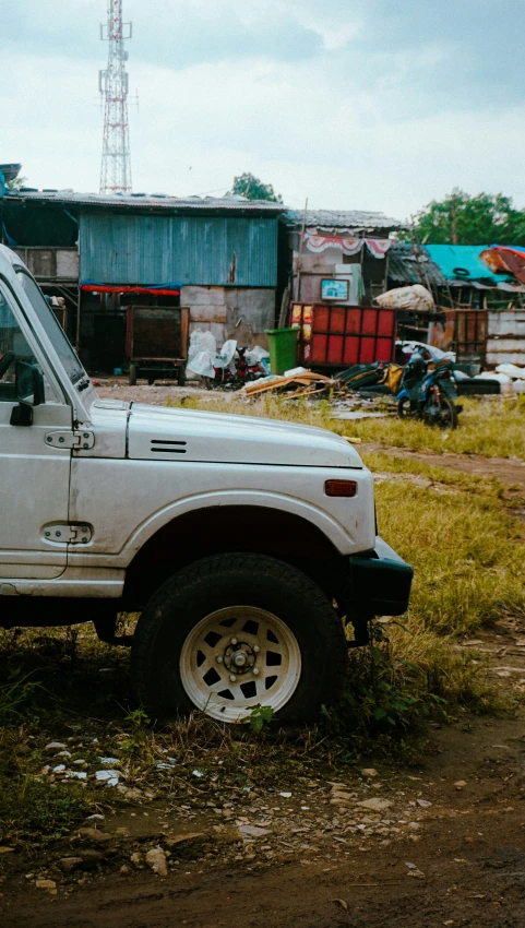 a big white truck parked next to a wooden shack