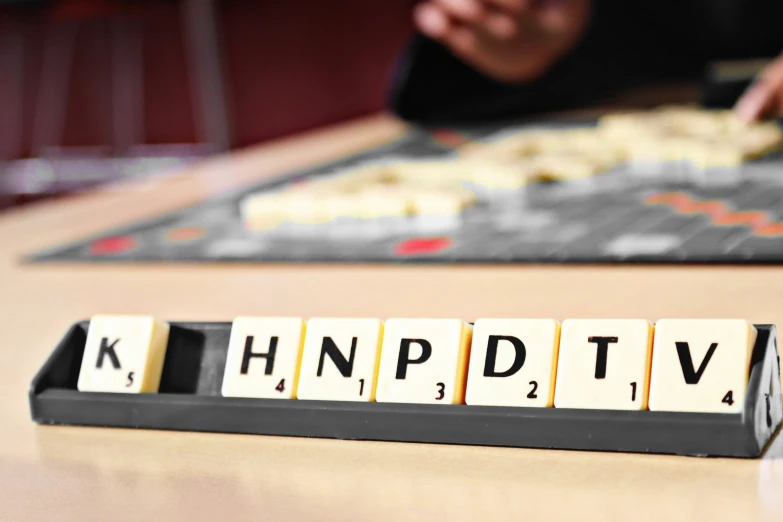 a scrabble tiles spelling knp tv on a table