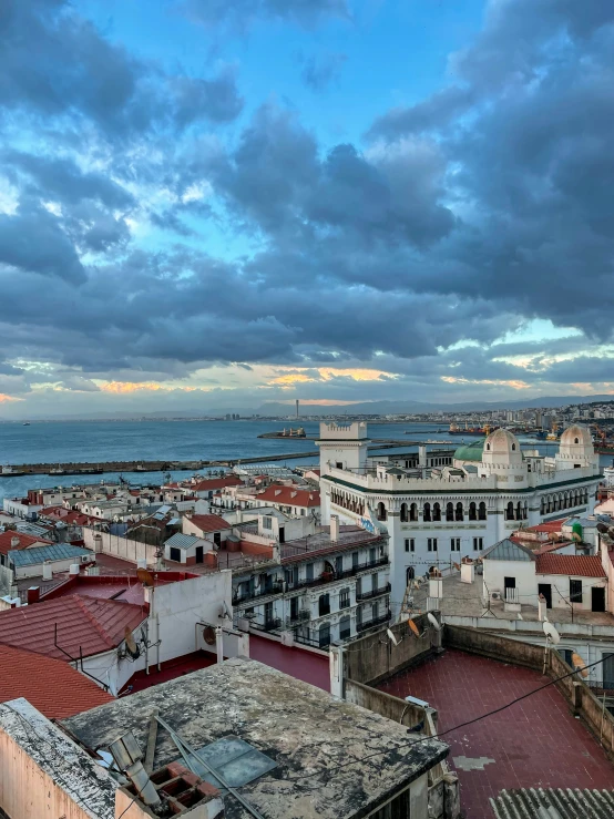 a cloudy sky above the city with old buildings and red roofs