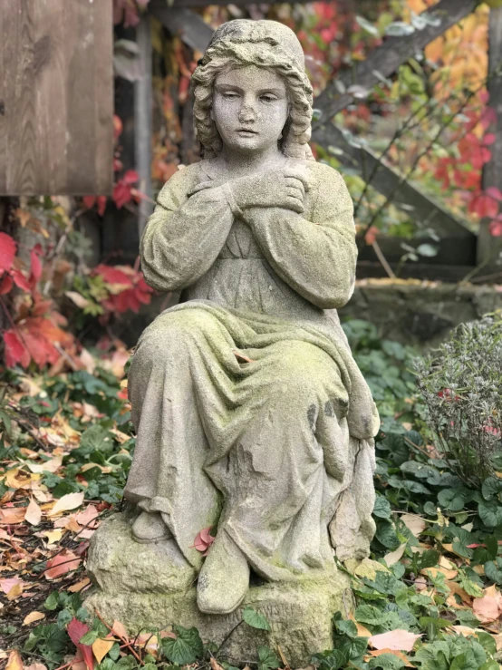 an old statue sitting on a pedestal in the grass