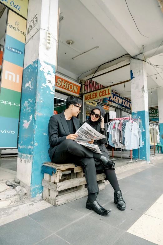 a couple of people sitting down outside a store