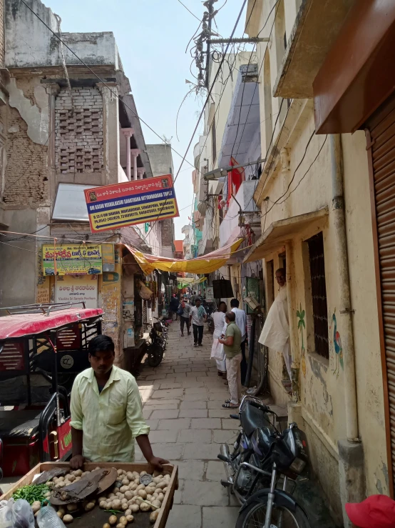 a man standing by a vendor selling food in an old city