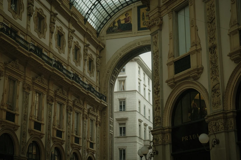 view from inside a large building looking at an arch and buildings