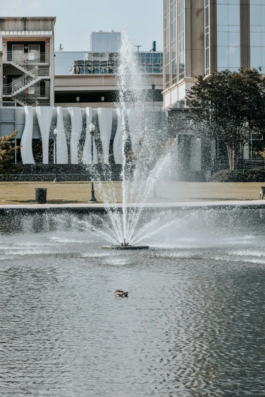 there is a water fountain on the pond