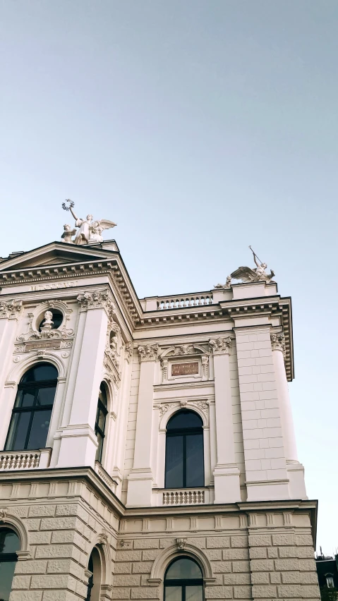 an old white building is on a street corner