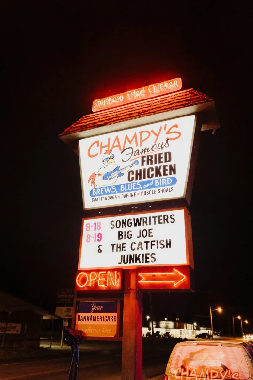 a red sign in the shape of a chicken restaurant