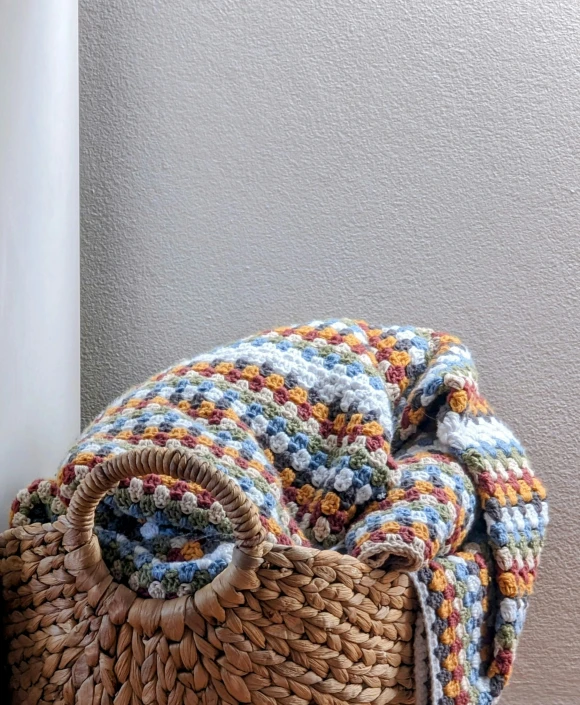 a colorful woven basket sitting on a wooden chair