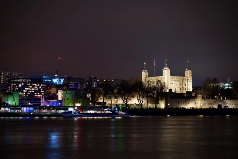 an urban city skyline at night with a few lights reflecting in the water