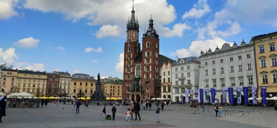 people standing on the square with several tall buildings