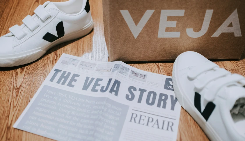 a pair of white shoes and a brown bag on the floor