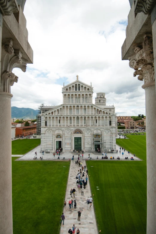 an elaborate building sits inside a square on a cloudy day