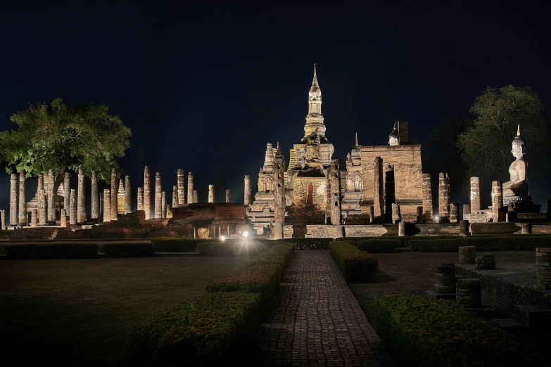 a castle is lit up at night near many trees