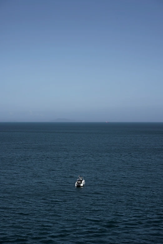 a boat floating on the ocean on a clear day