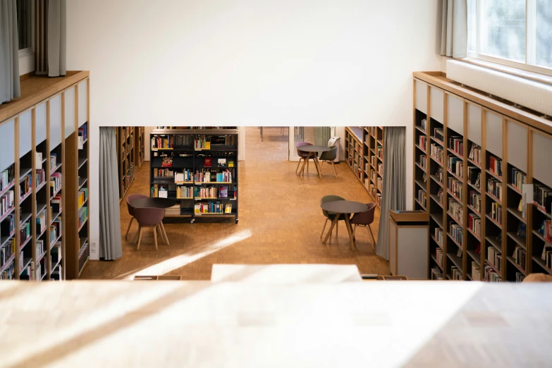 two tables with chairs and a book case