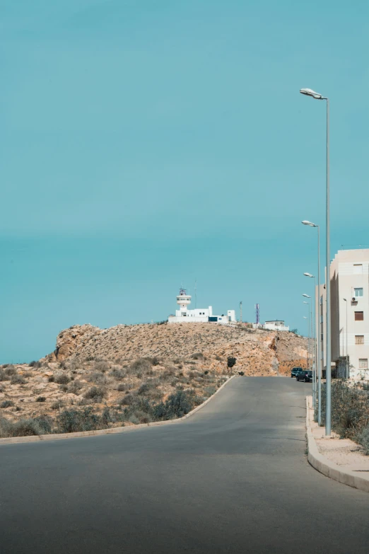 streetlight on top of hill with cars going down the street