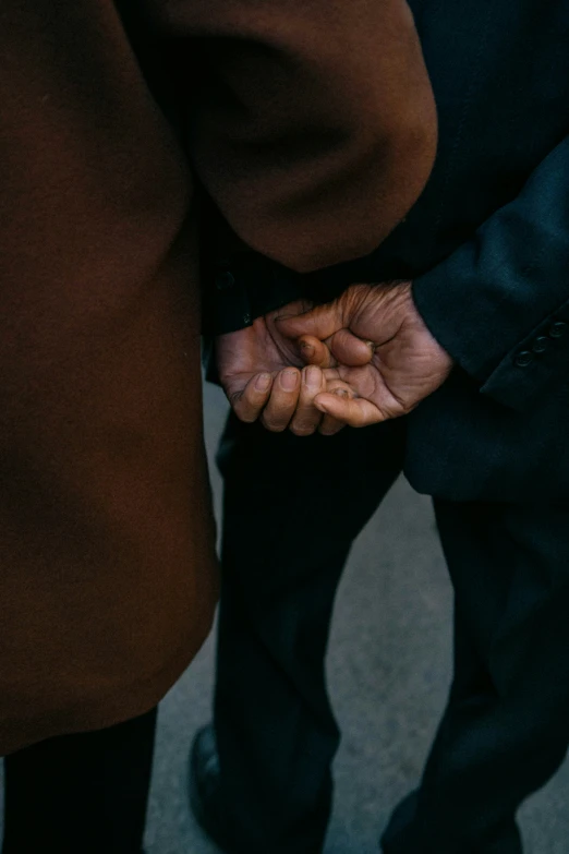 two people standing together while holding hands with others