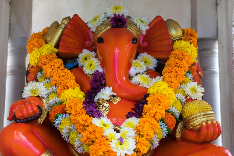 an indian statue of an elephant is surrounded by flowers and foliage