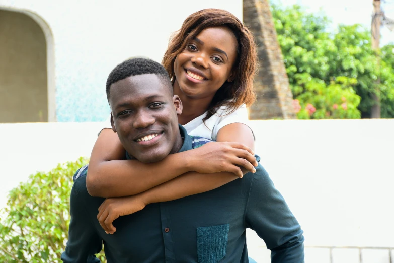 a beautiful black couple hugs each other for the camera