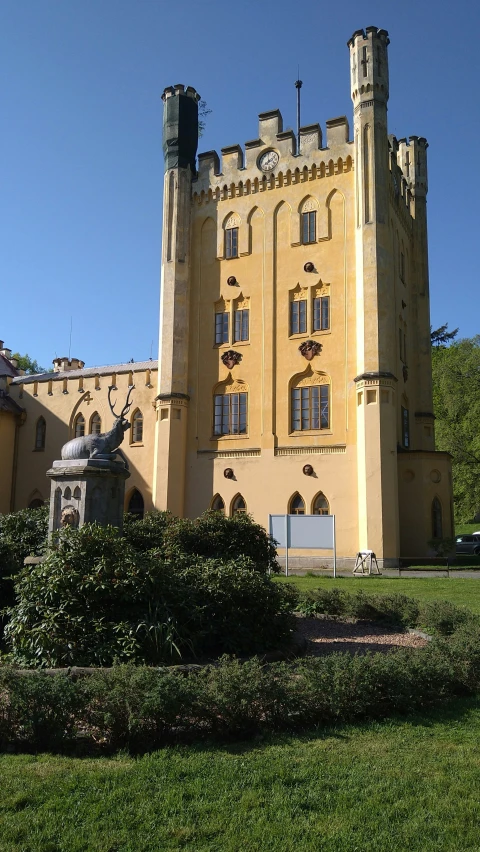 an ornate building in front of some bushes