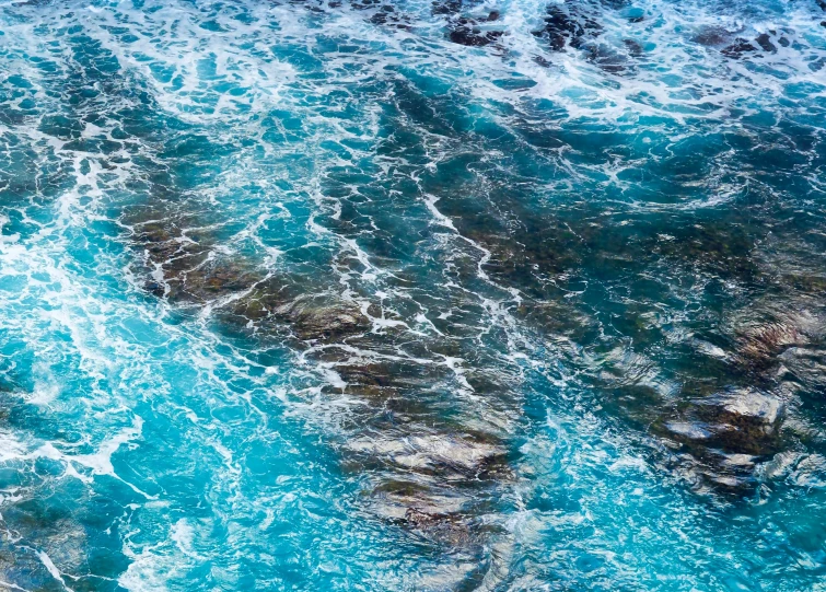 the water at the bottom of the rocks looks like foam