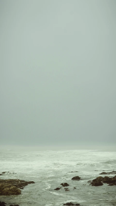 a lone surfer is out in the ocean looking at the horizon