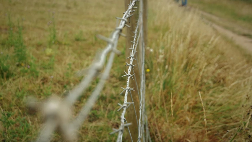 a row of barbed wire fence with the end of each section attached