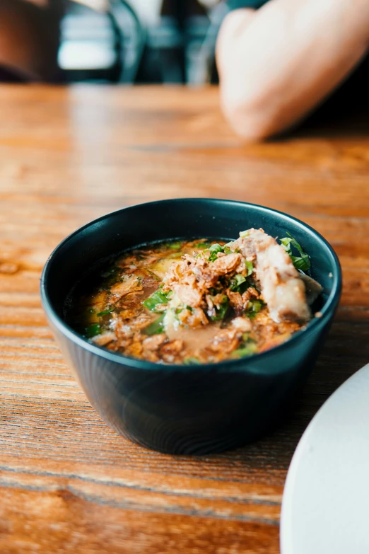 a bowl of food sits on the table in a restaurant