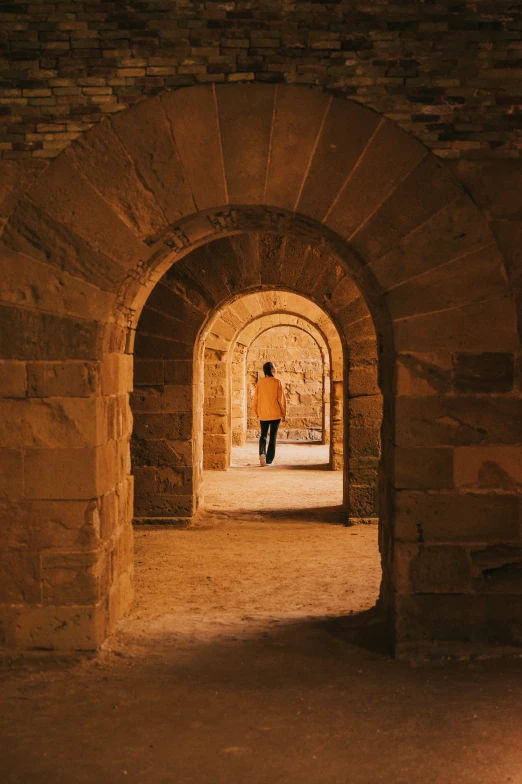 a man standing on the sidewalk at an arched doorway