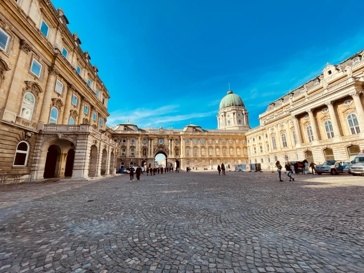 looking down on a cobblestone walkway leading to a large building