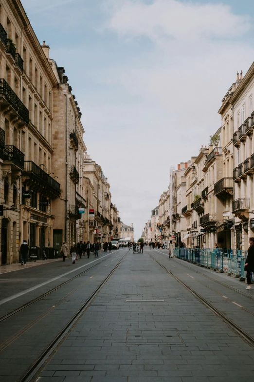 an empty street with multiple buildings and people walking along it