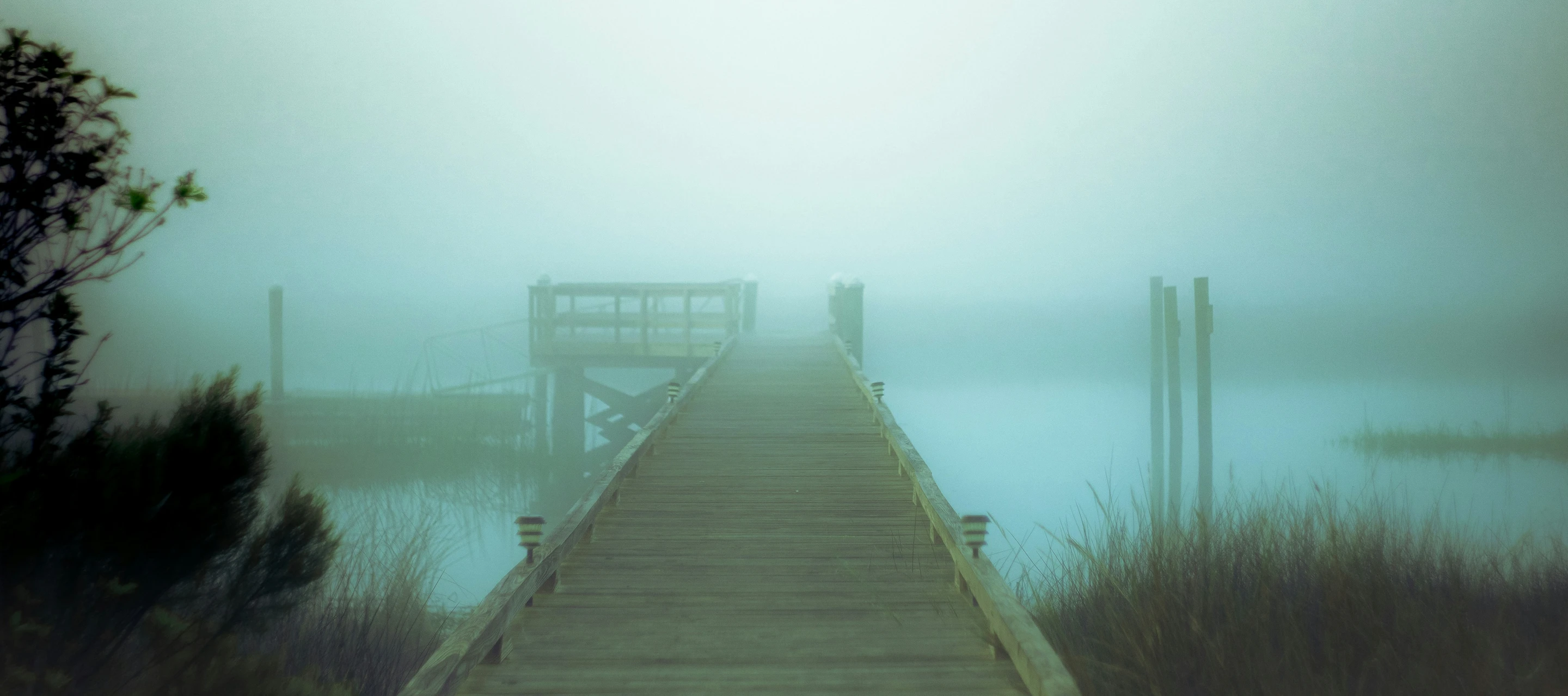 fog rolls in as the sun is going down on a dock